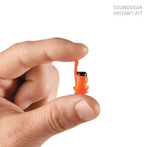A man holding the Sounder Instant Fit Digital in-the-canal hearing aids between his thumb and index finger to show how small they are