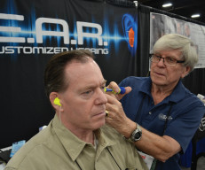 Garry Gordon, founder of E.A.R. Inc., fits SCI Life Member Douglas Bailey for a new pair of hearing protection devices at the SCI Convention earlier this year.
