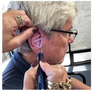 Woman using a EAR/BeBird M9-S with clear illumination tip to examine a man's ear canal.