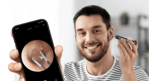 Earinc, Boulder Colorado, man using a Bebird digital otoscope and showing image of ear canal on smartphone