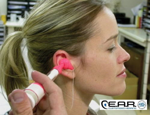 Woman getting ear molds for custom hearing protection at EAR Customized Hearing in Boulder, CO